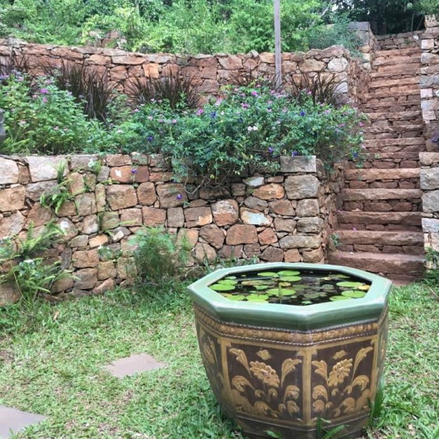 Stone terraced garden with lily pond at Palani Hills